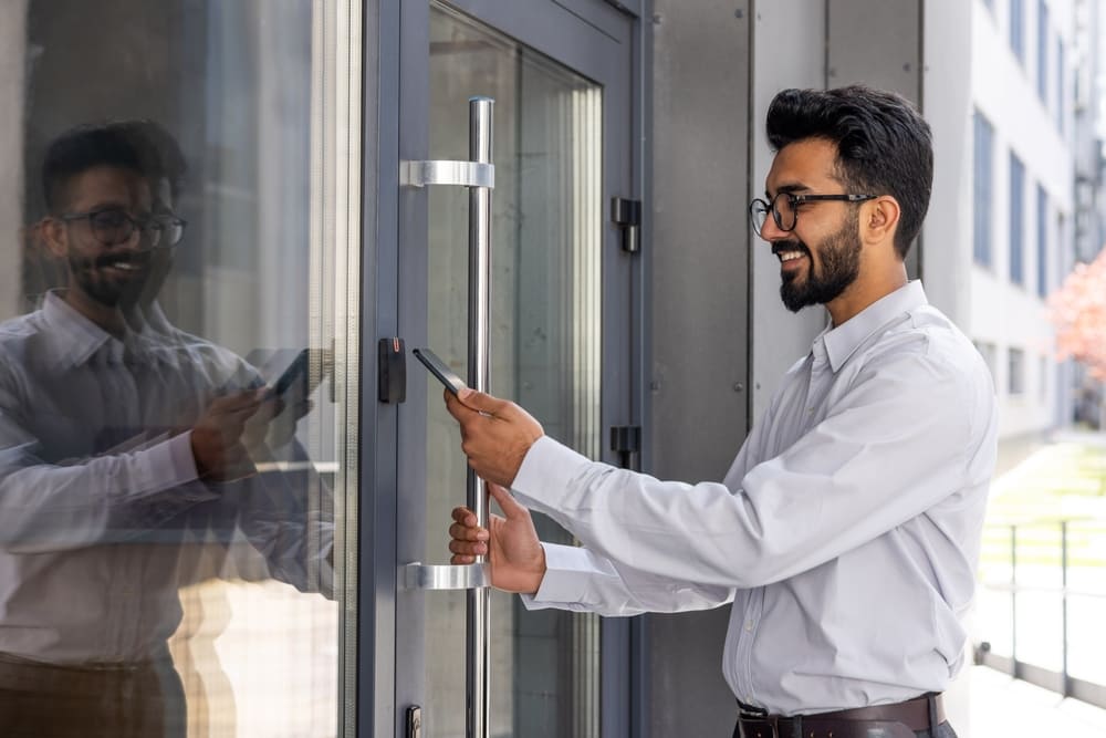 Mann öffnet Haustür keyless mit Smartphone